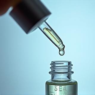 Detailed shot of a clear serum bottle with a dropper applicator, focusing on the liquid and packaging